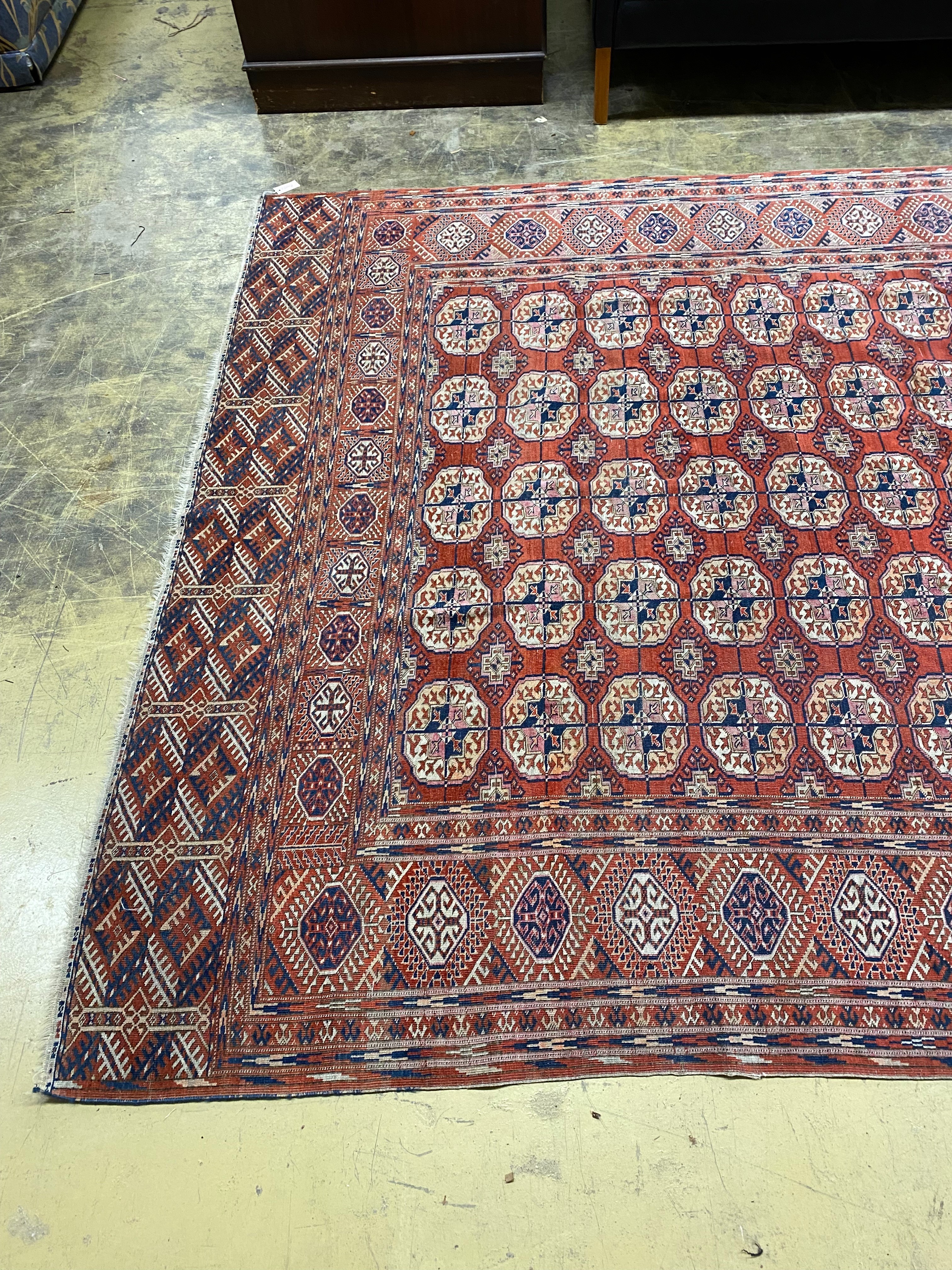 A Bokhara brick red ground carpet, 350 x 230cm